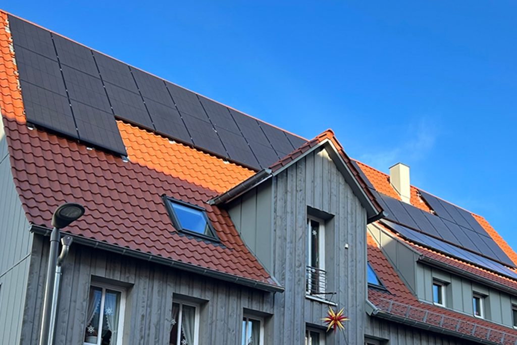Teilansicht eines Hauses mit einer Photovoltaikanlage auf dem Dach.