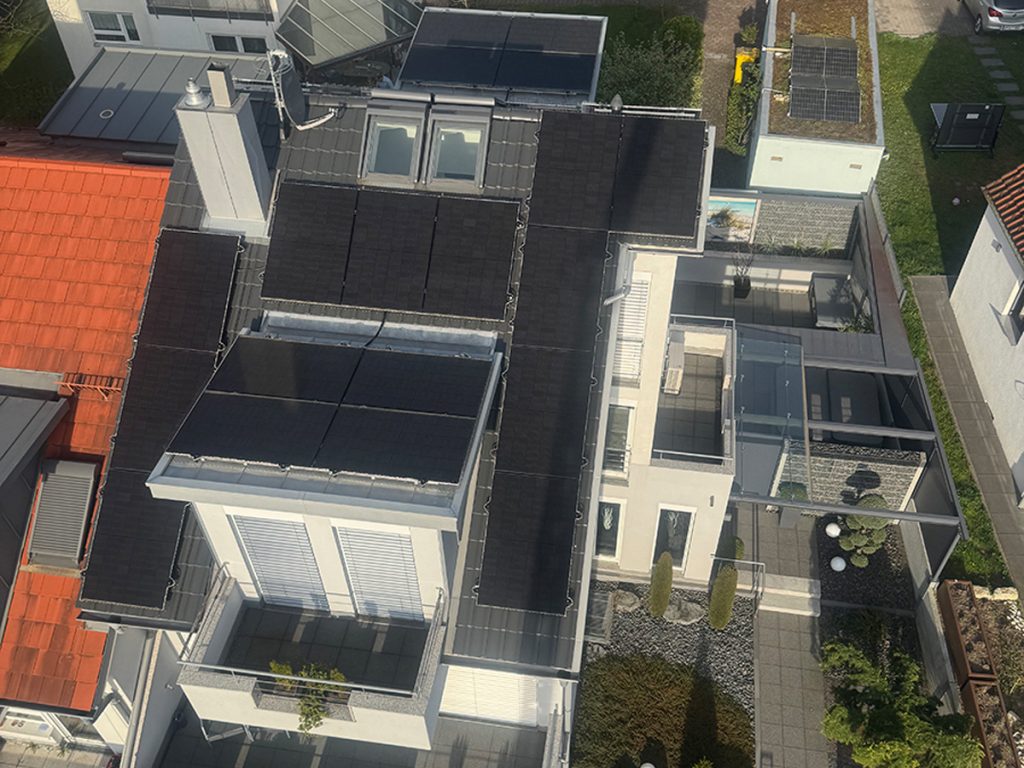 Ein Einfamilienhaus mit Photovoltaikanlage auf dem Dach, fotografiert aus der Vogelperspektive.
